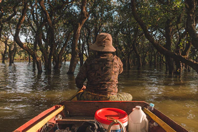 Hunters in camouflage gear quietly navigating a shallow marsh in a Carolina Skiff with pop-up blind.