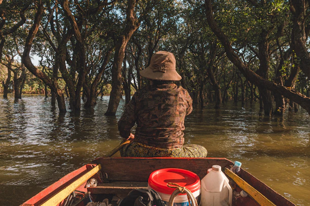 Photo of a rugged 16’ Carolina Skiff equipped with a camouflaged pop-up blind in a marsh at sunrise.