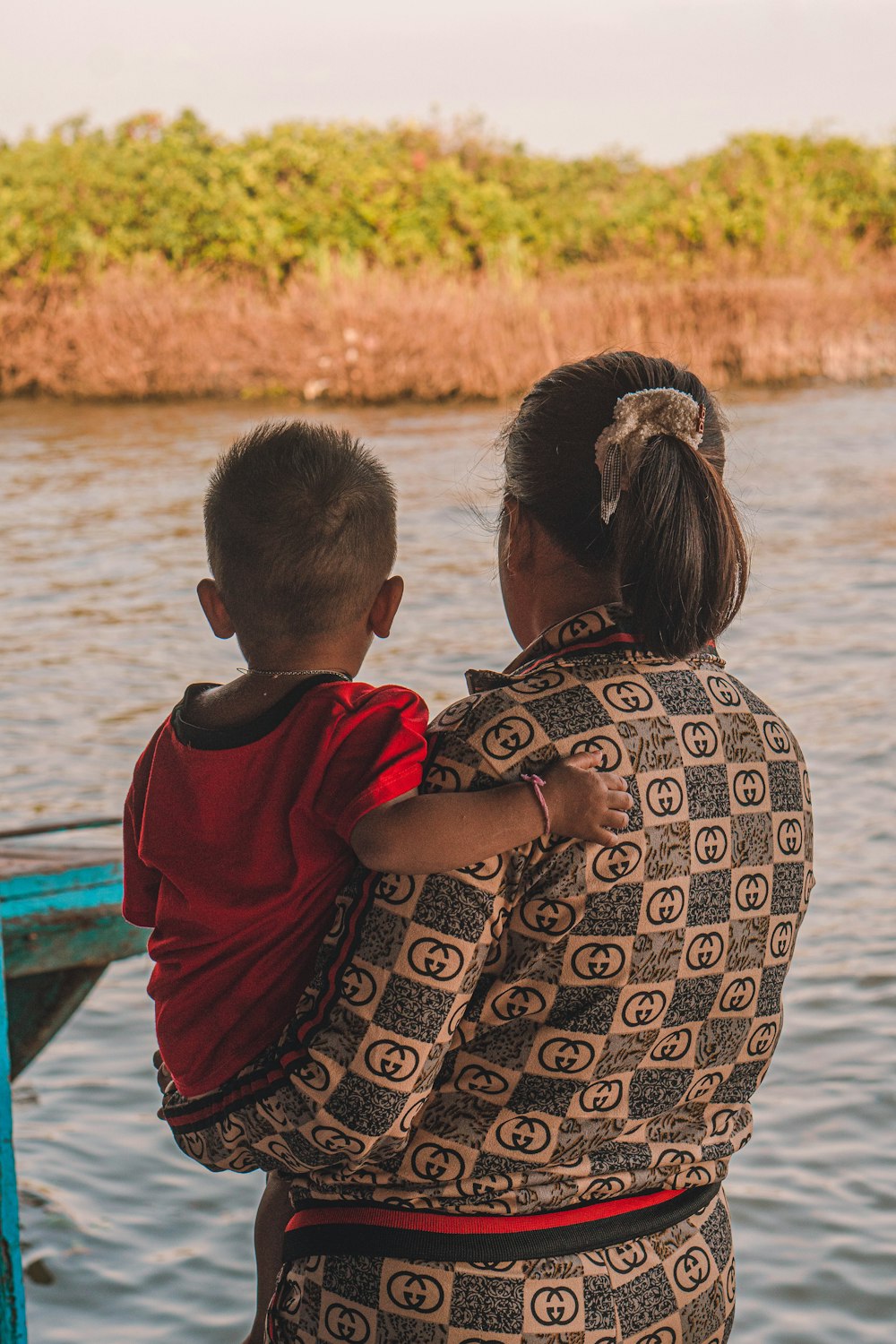 Une femme tenant un enfant sur le toit d’un bateau