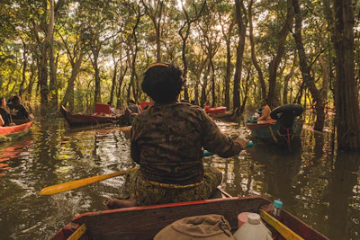 Canoe paddling through a narrow flooded forest channel near Siem Reap (via Unsplash)