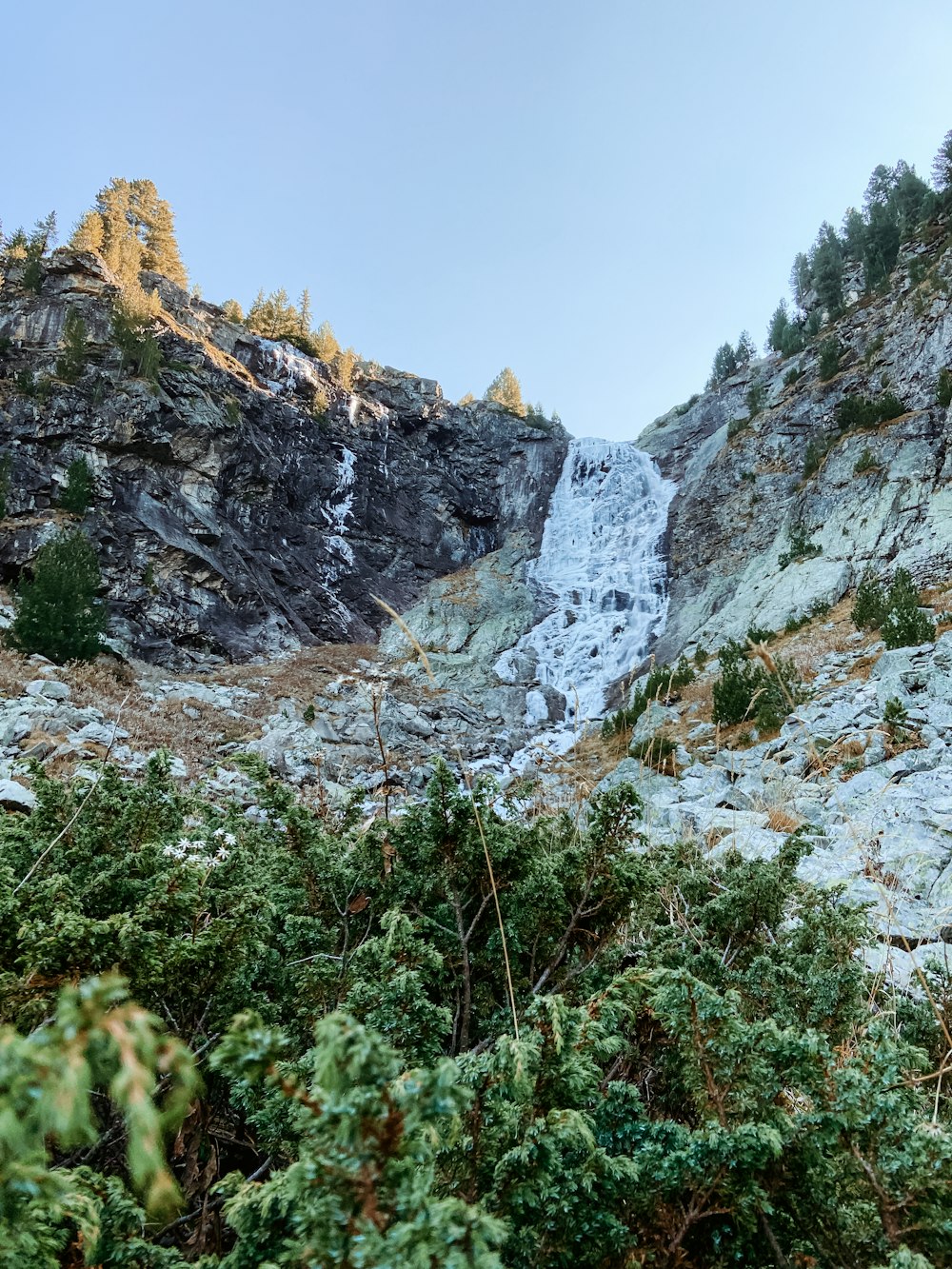 a very tall waterfall in the middle of a forest