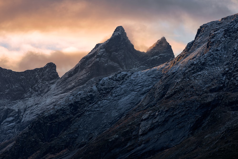 a very tall mountain with some clouds in the sky