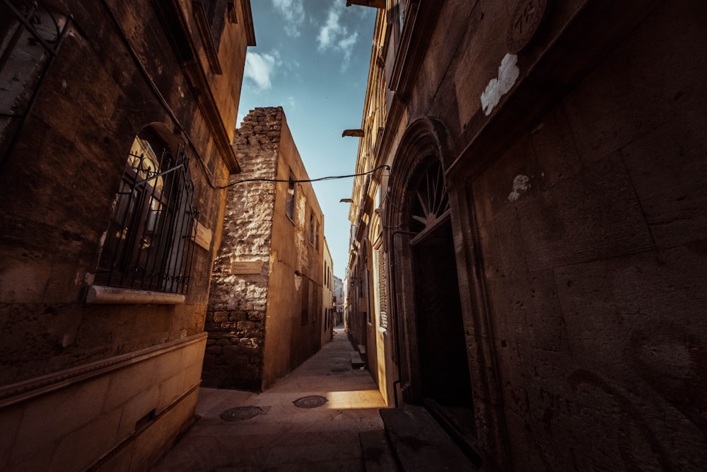 um caminho de beco estreito com um edifício de pedra ao fundo