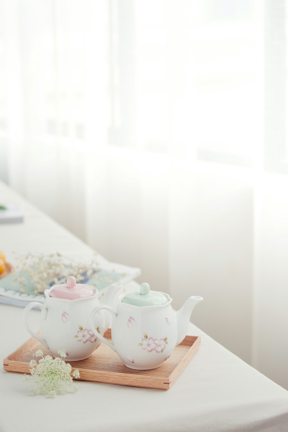a tray with two teapots sitting on top of a table
