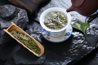 a cup of green tea next to a container of green tea