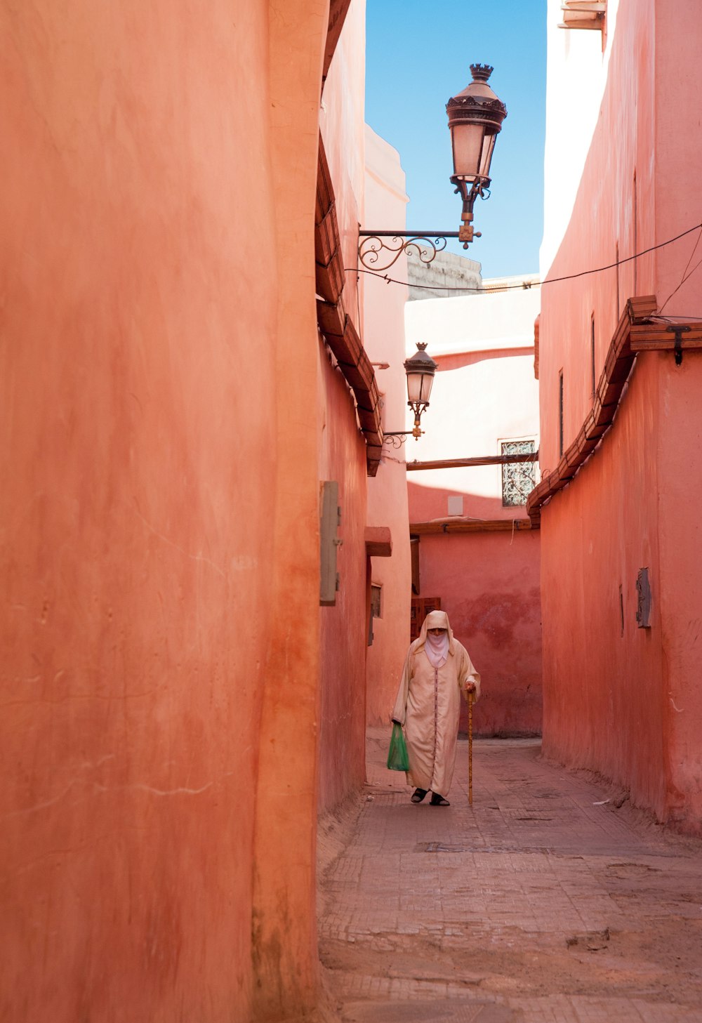 a woman walking down a narrow alley way