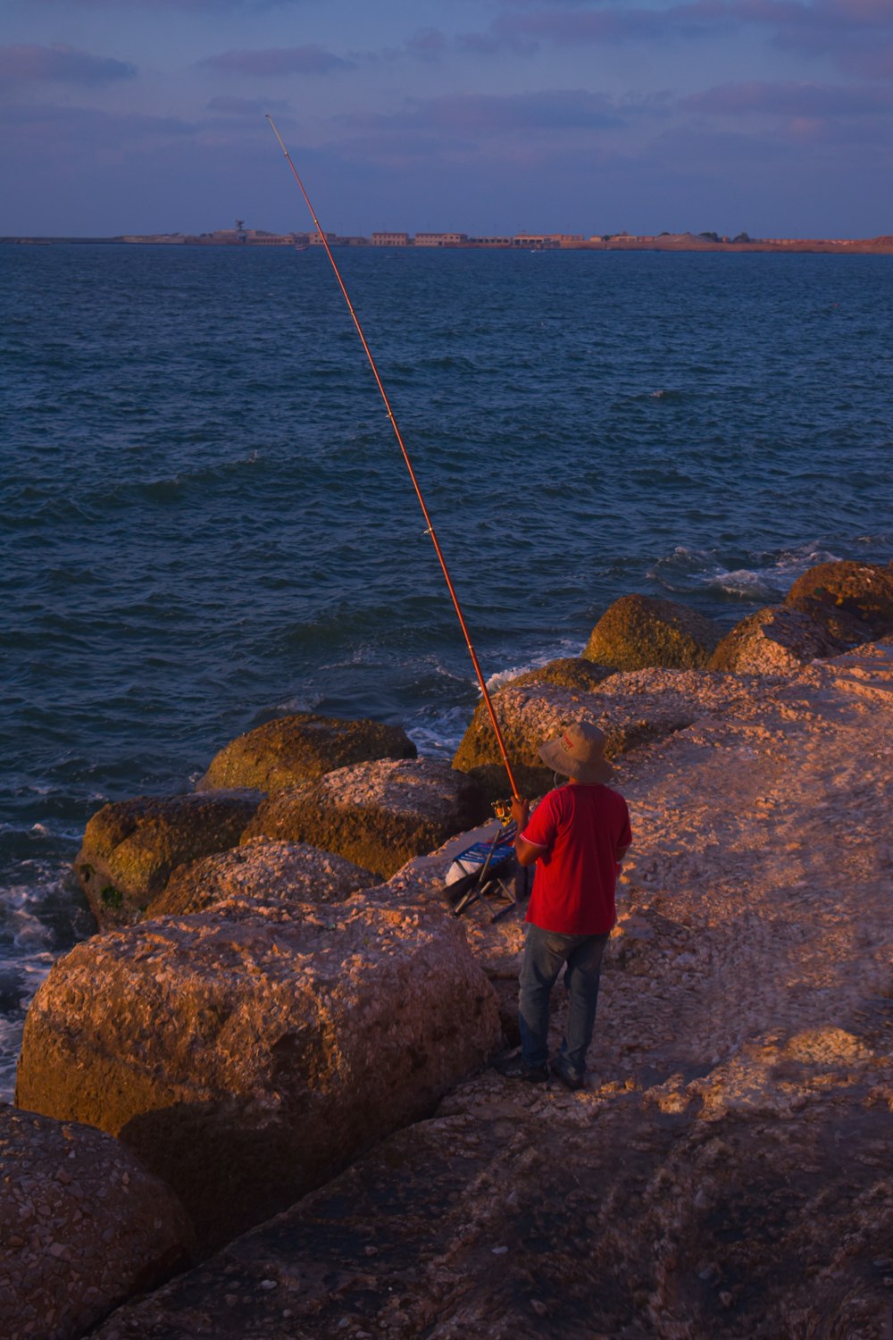 Un uomo in piedi su una roccia accanto a uno specchio d'acqua