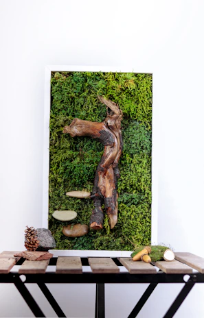 A sculptural statement piece featuring a vintage rustic wood frame intertwined with weathered driftwood branches and adorned with delicate faux magnolia flowers.