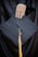 A hand with manicured nails rests on a black graduation cap, which features a yellow tassel hanging from the center.