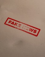 a stamp that reads fake news on a piece of paper