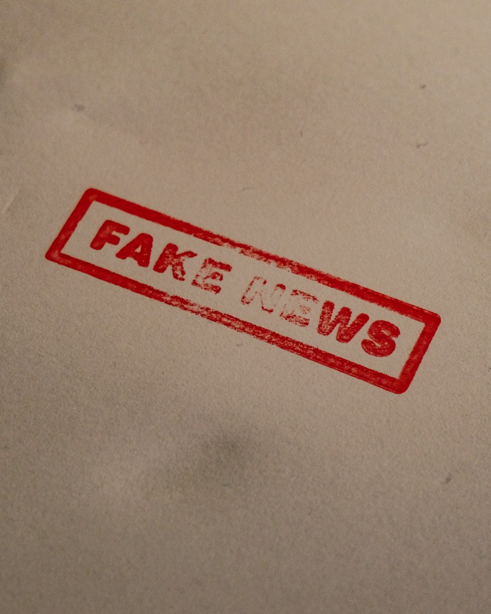 a stamp that reads fake news on a piece of paper