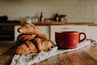 A cozy kitchen scene with a basket filled with croissants and pain au chocolat.