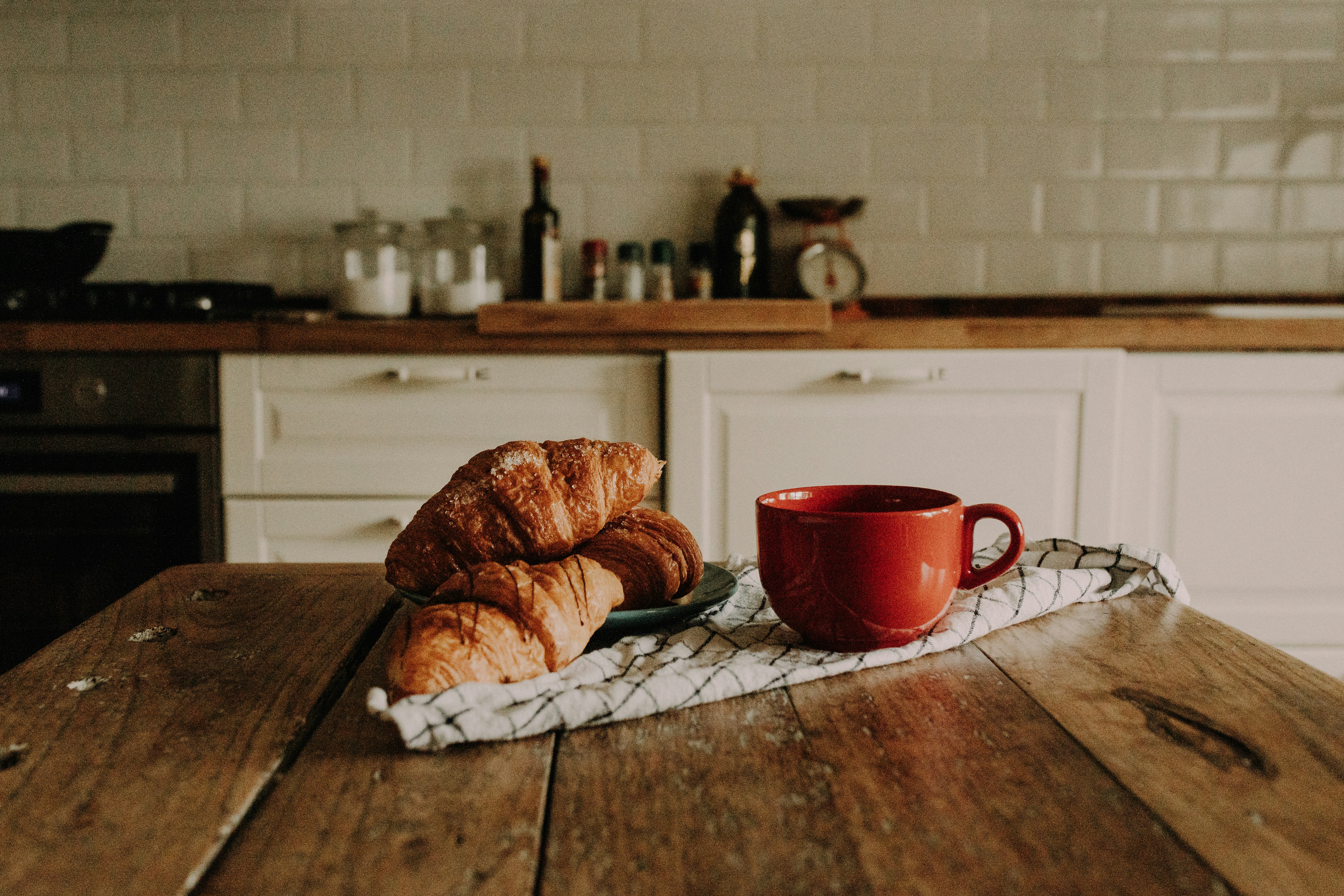 Croissants and a cup of coffee on a kitchen table