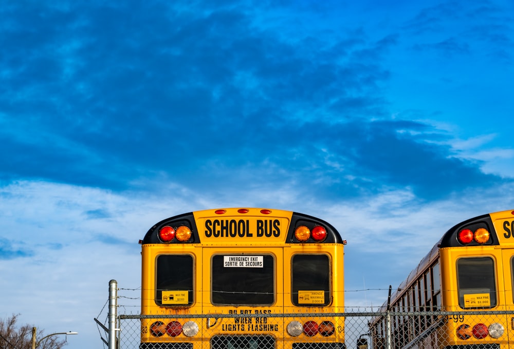 two yellow school buses parked next to each other