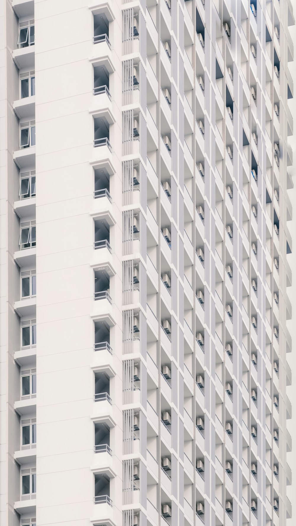 a tall white building with balconies and windows