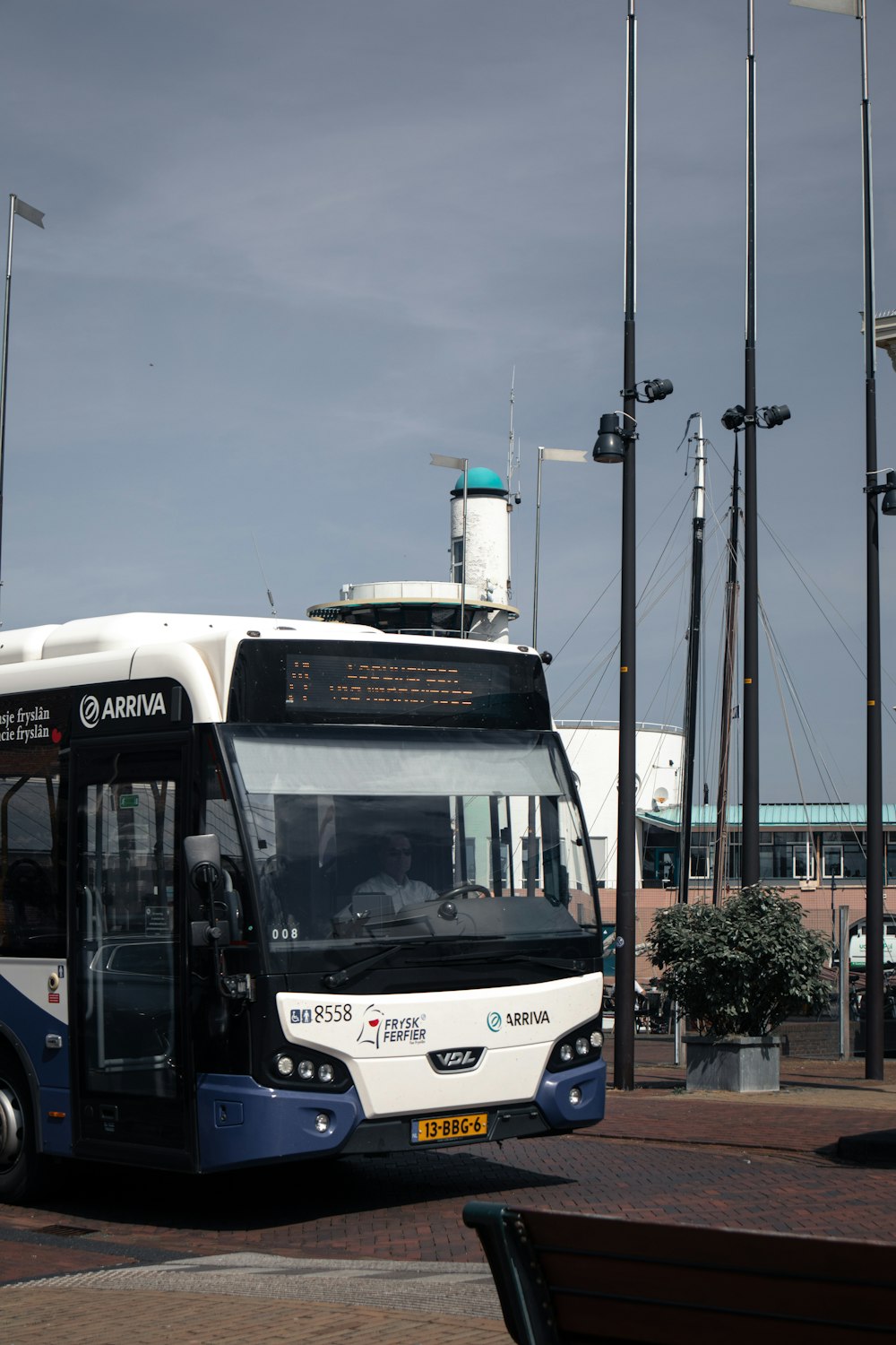 a white and blue bus driving down a street