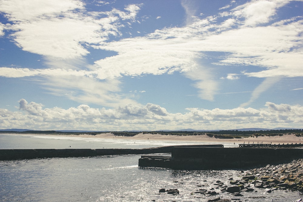 a body of water sitting next to a sandy beach