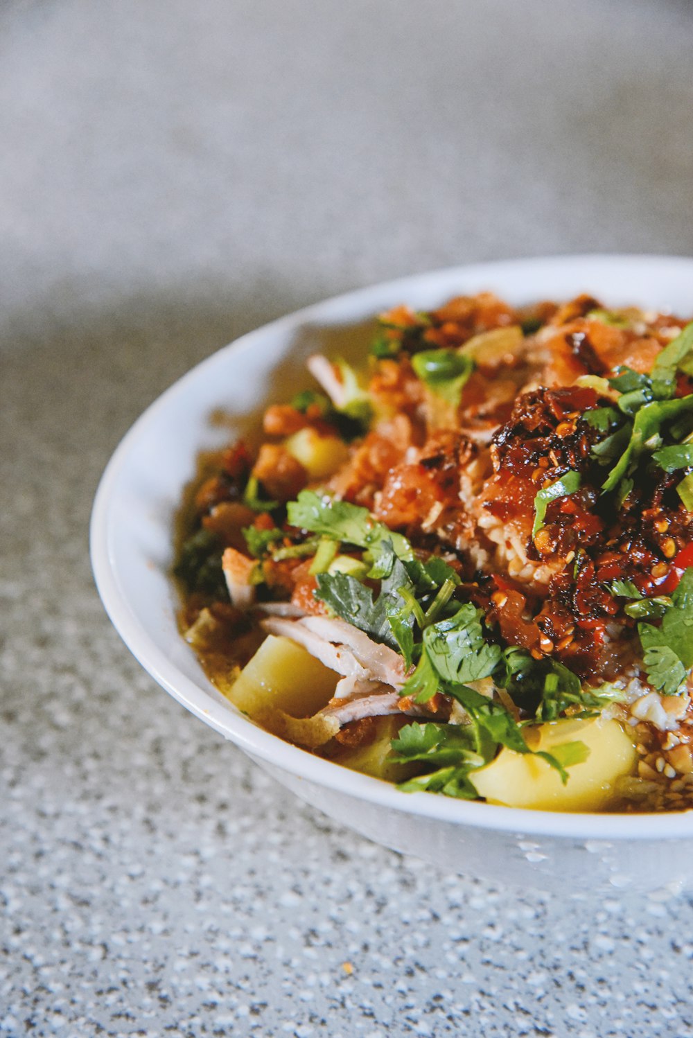 a white bowl filled with food on top of a table