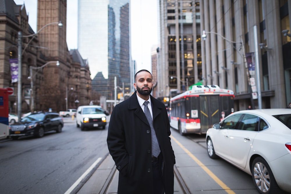 a man in a suit and tie standing on a city street