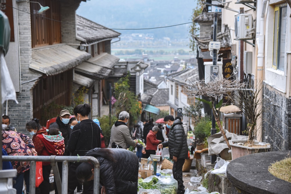 a group of people walking down a street next to buildings