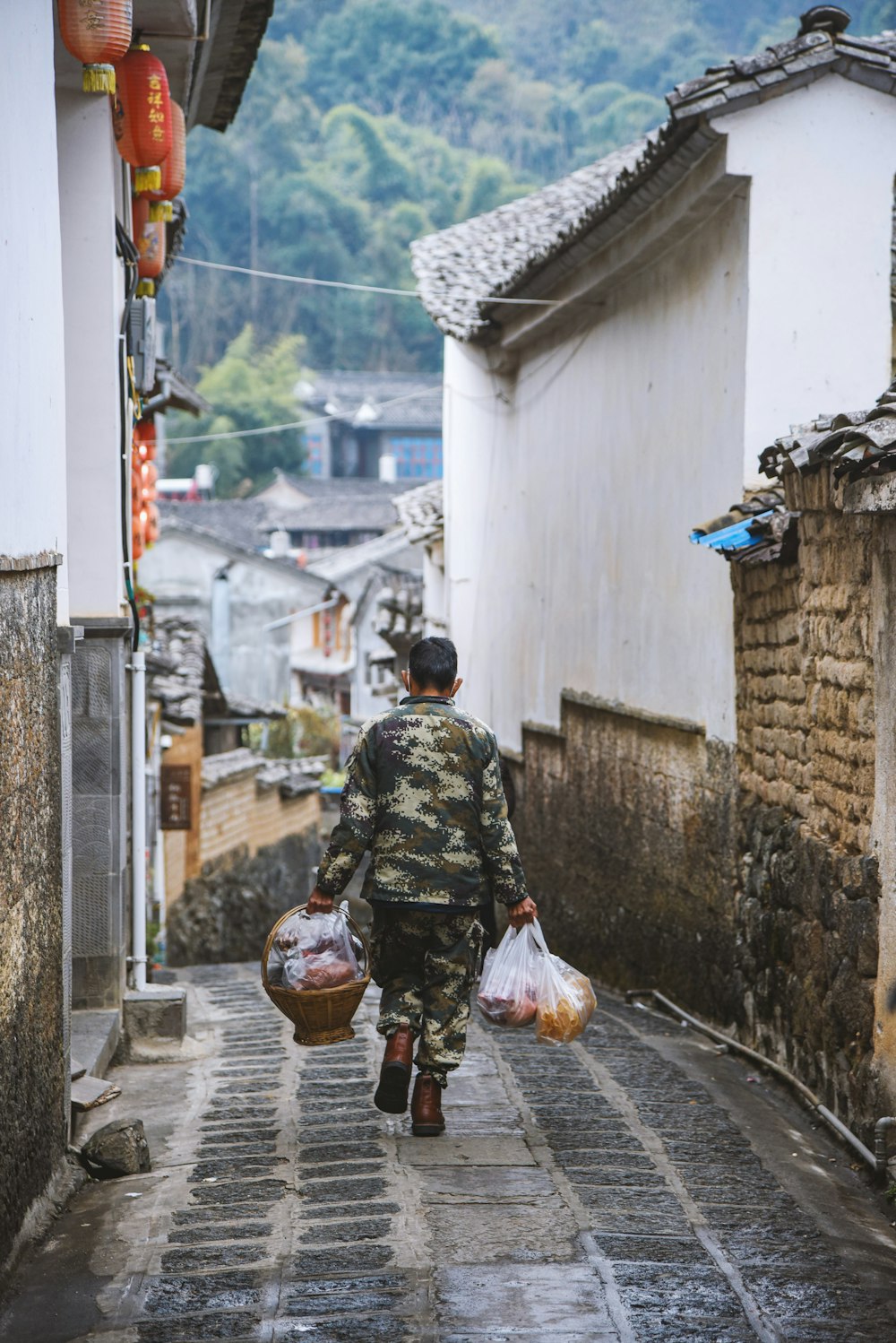 a man walking down a street carrying bags of food