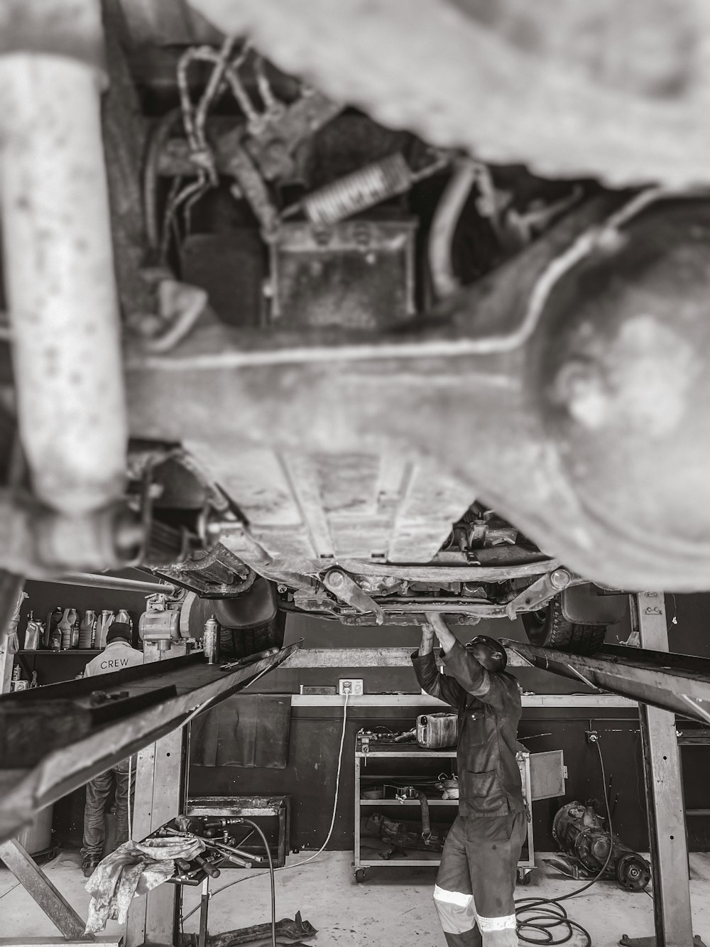 Una foto en blanco y negro de un hombre trabajando en un vehículo