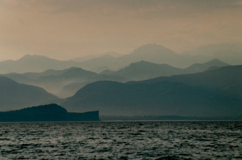 a large body of water with mountains in the background