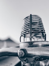 A monochrome image of a vintage microphone against a black background