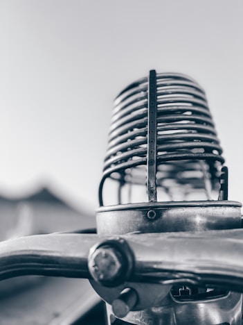 A monochrome image of a vintage microphone against a black background