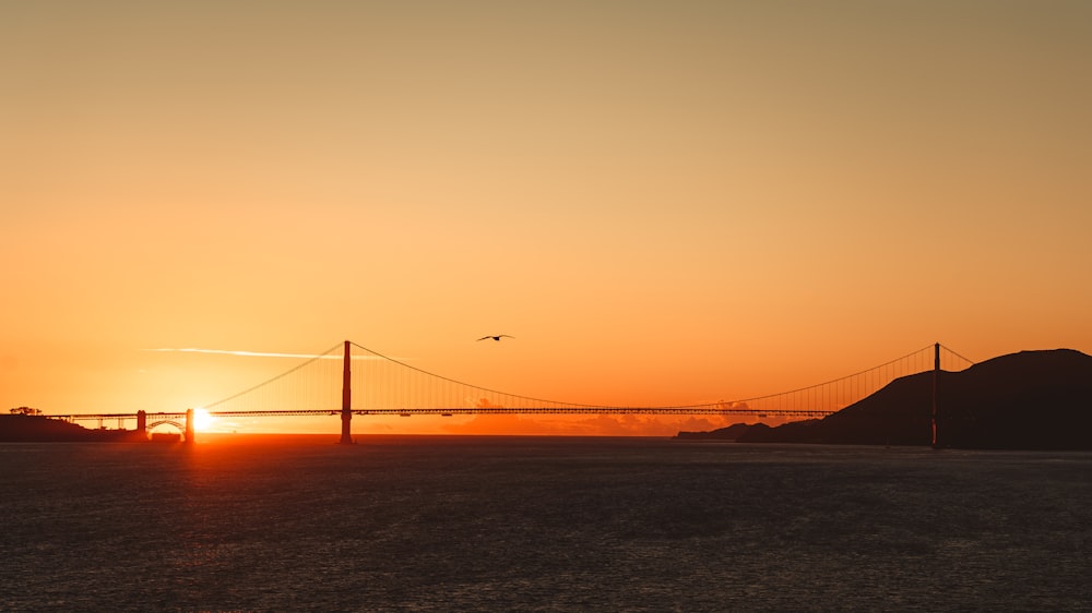 the sun is setting over the golden gate bridge