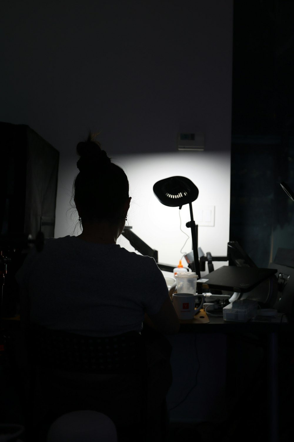 a person sitting at a desk in a dark room