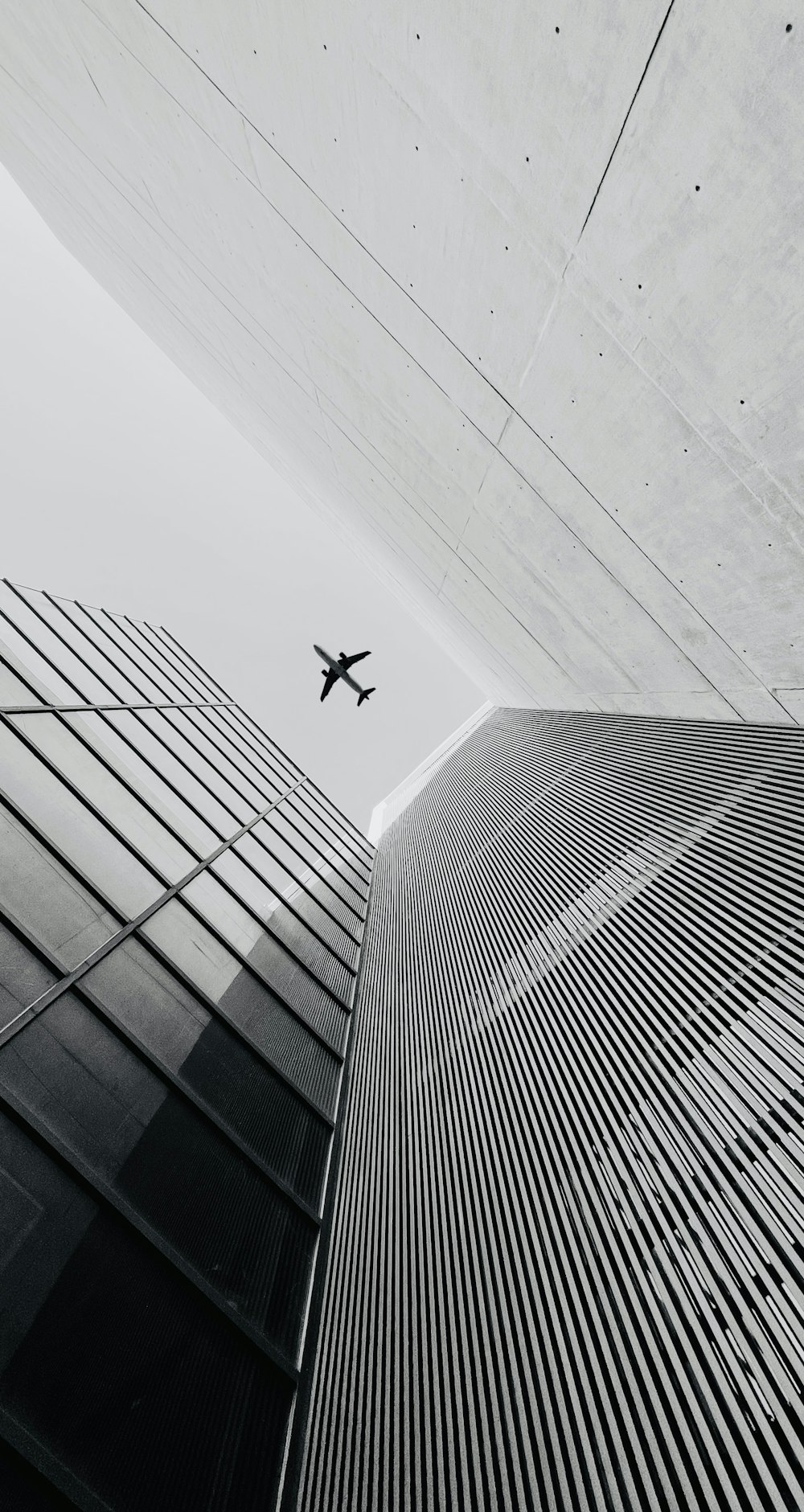 a black and white photo of a plane flying in the sky