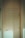 Close-up of a modern wooden door with sleek metal handle in natural light.