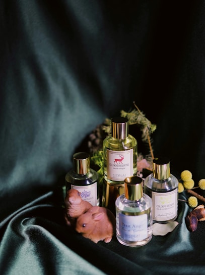 Artistic arrangement of perfume bottles surrounded by symbolic art elements inspired by Gustave Moreau