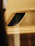 Close-up of a matte black and gold jet ski accessory gleaming under soft ambient lighting.