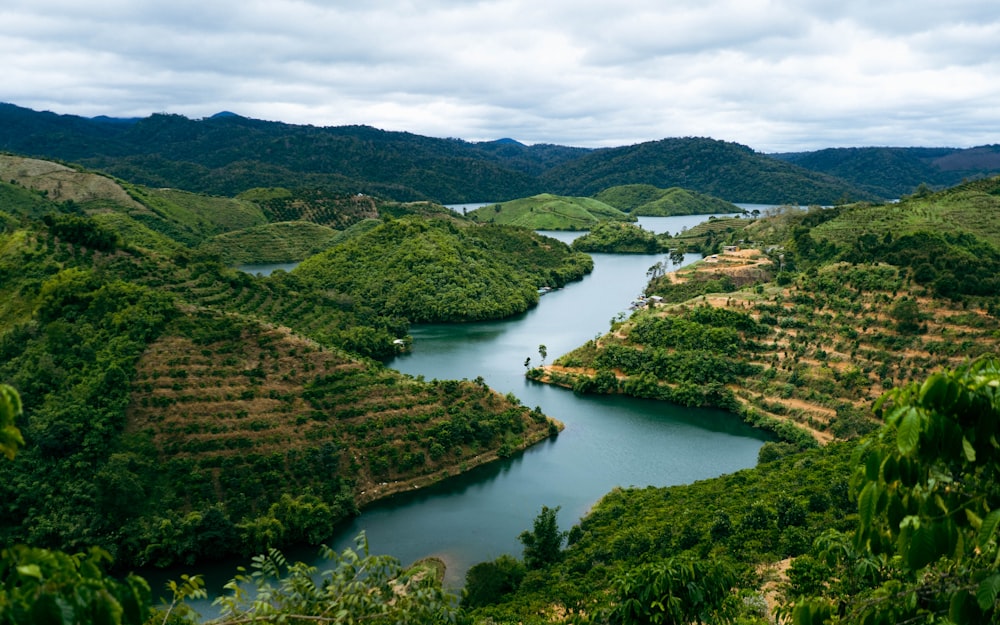 a lake surrounded by lush green hills and trees