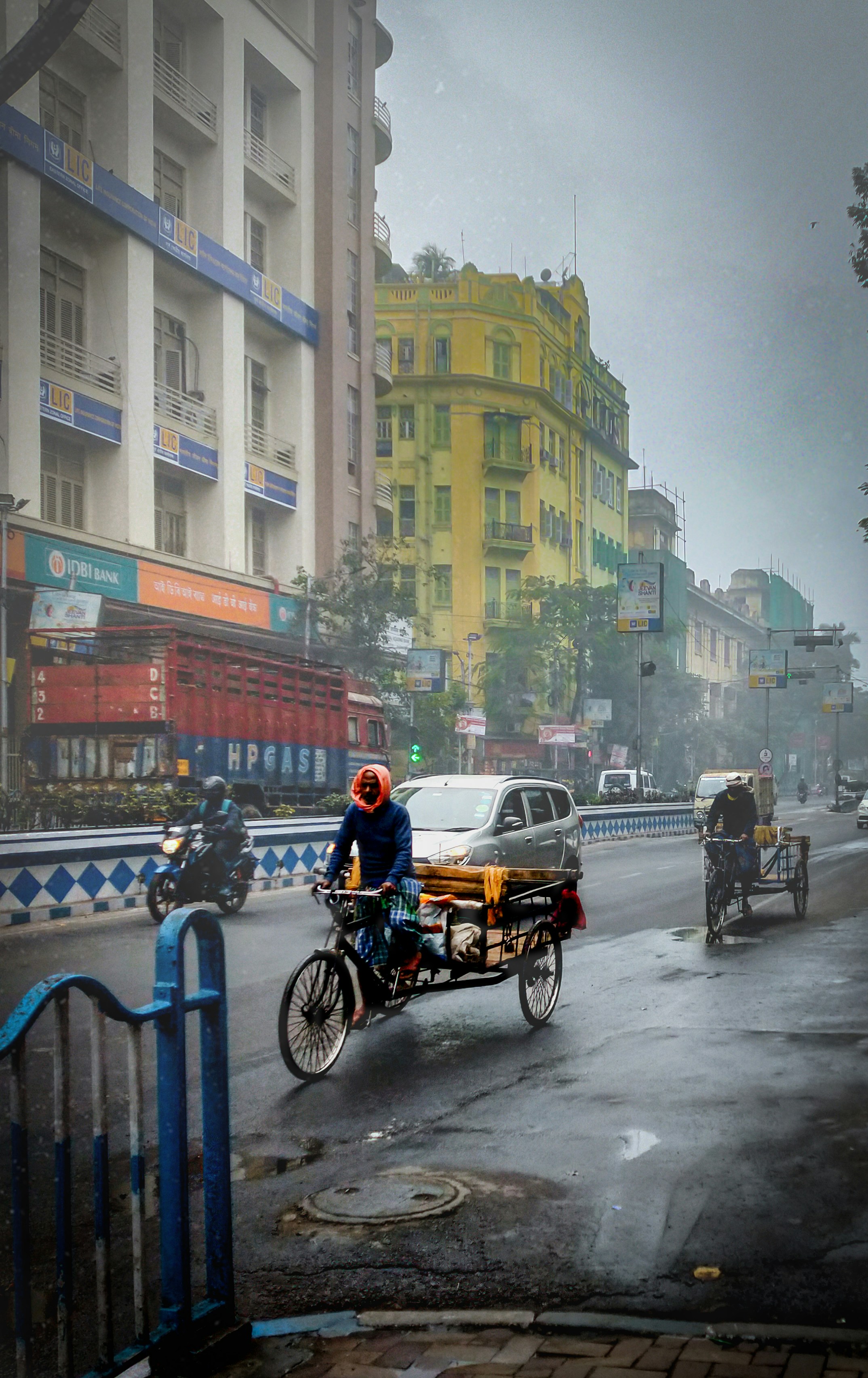 a man riding a bike with a cart on the back of it
