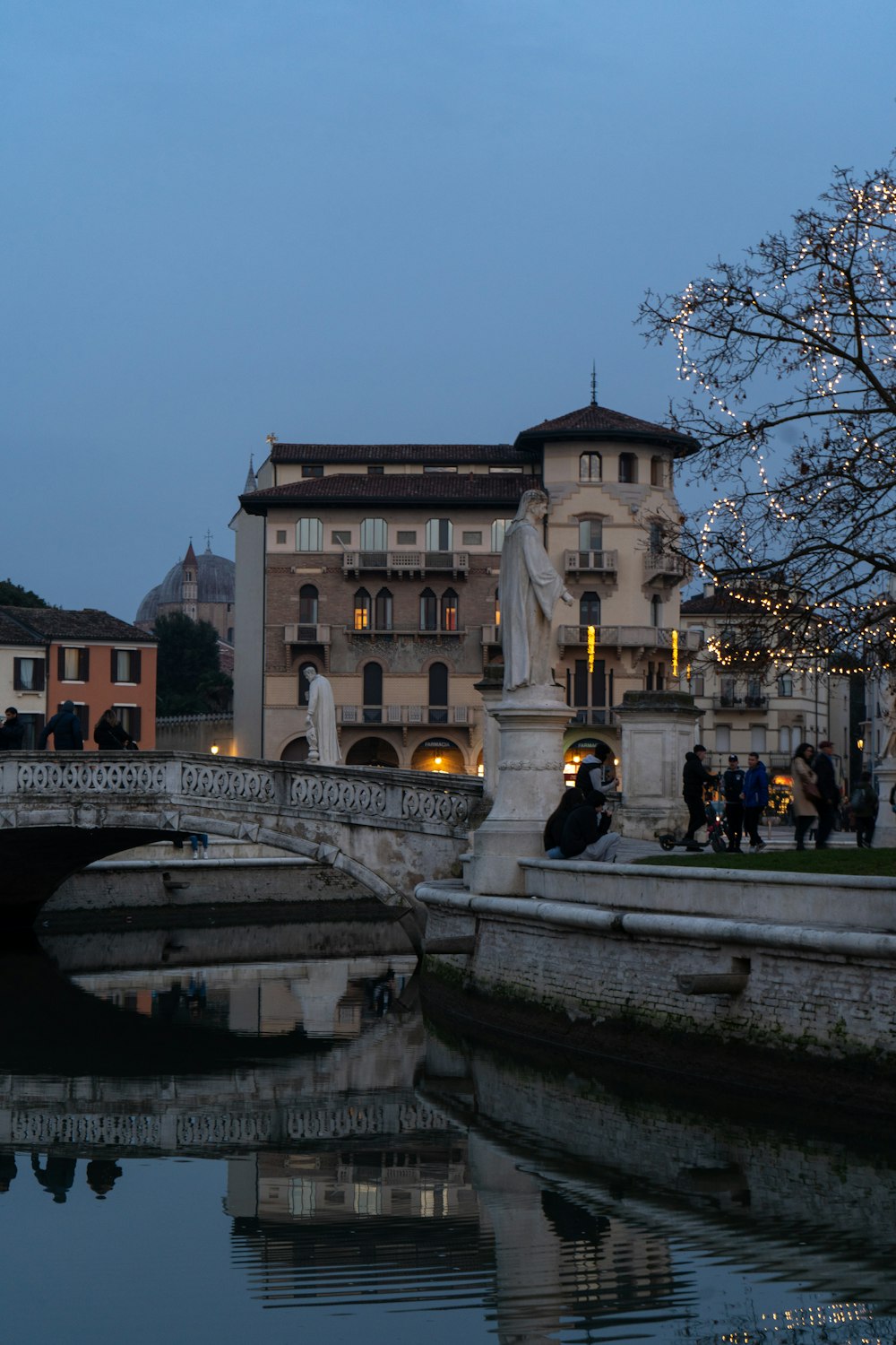 a group of people walking across a bridge over a river