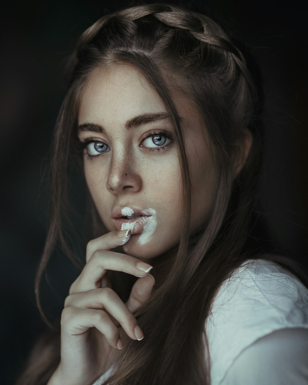 a woman with blue eyes is brushing her teeth