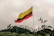 a flag flying in the wind on top of a hill