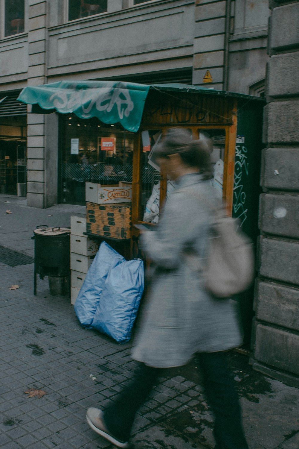 a woman walking down a street past a store