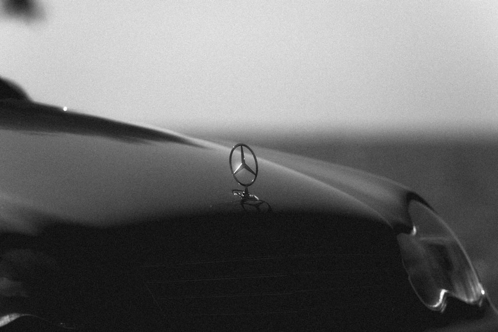 a black and white photo of a car hood ornament
