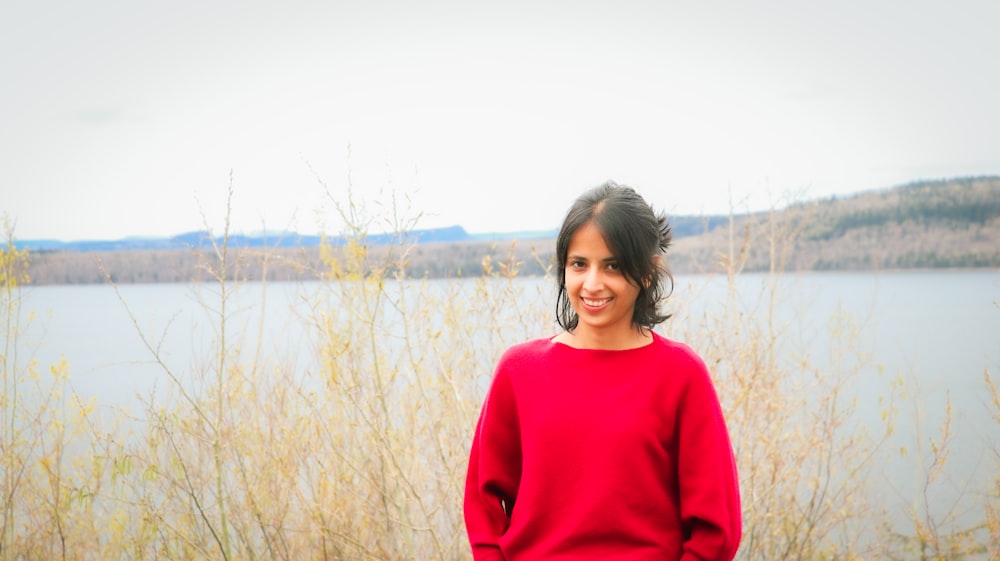 a woman standing in front of a body of water