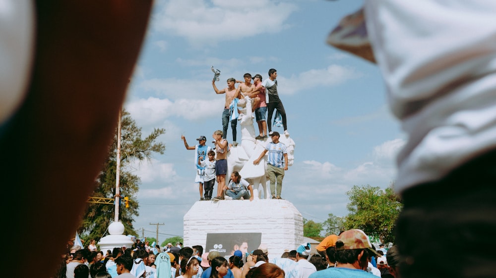 um grupo de pessoas em pé no topo de uma estátua
