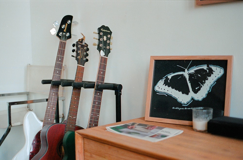 a couple of guitars sitting on top of a wooden table