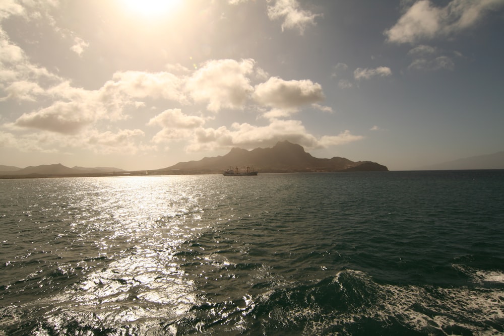 a large body of water with a mountain in the background