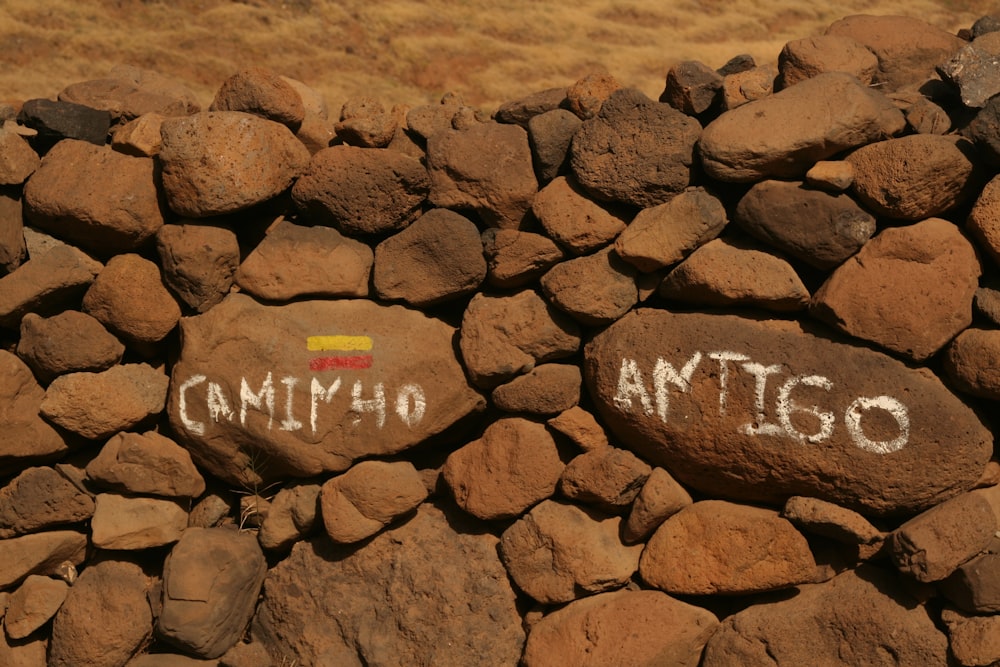 a rock wall with graffiti written on it