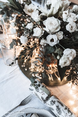 Close-up of a sophisticated floral centerpiece in dark green and silver tones.