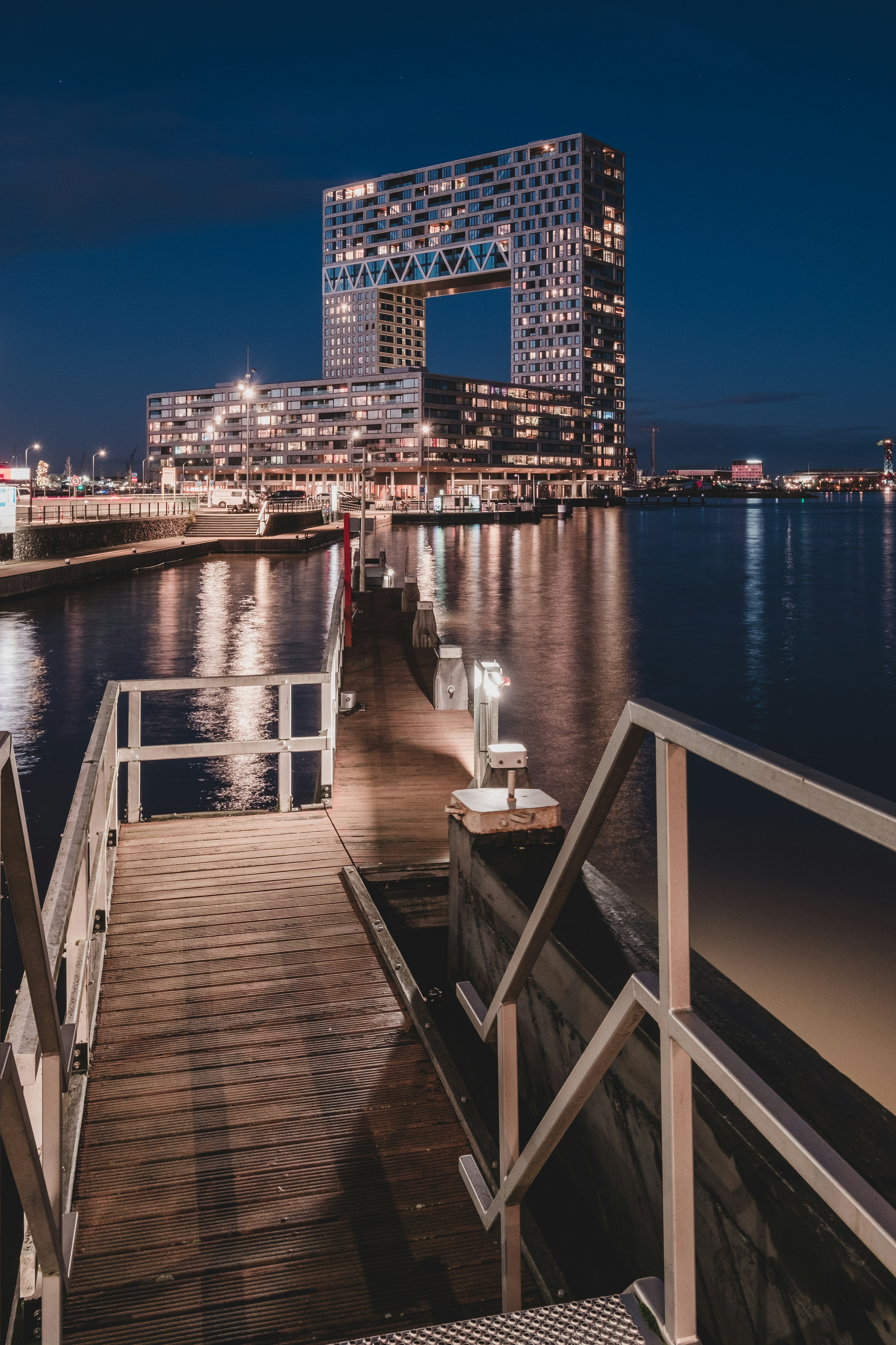 a wooden dock with a bench on it next to a body of water