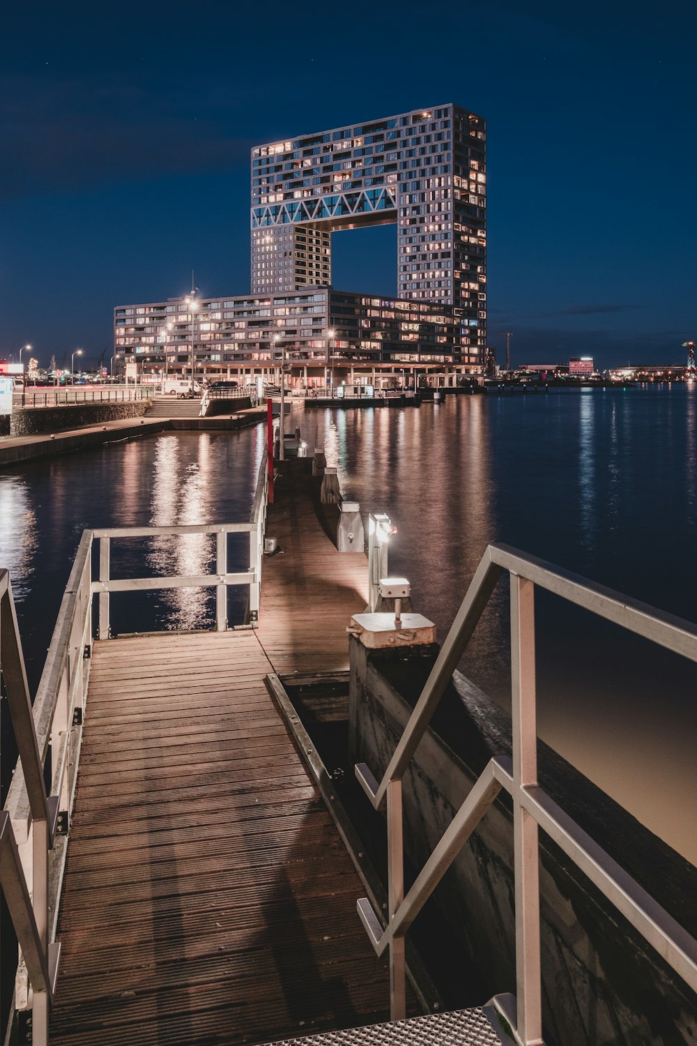 a wooden dock with a bench on it next to a body of water